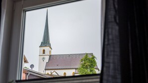 Una finestra con vista su un edificio con una guglia e un orologio.