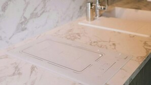 Un bagno con un piano in marmo, un lavandino e un rubinetto.