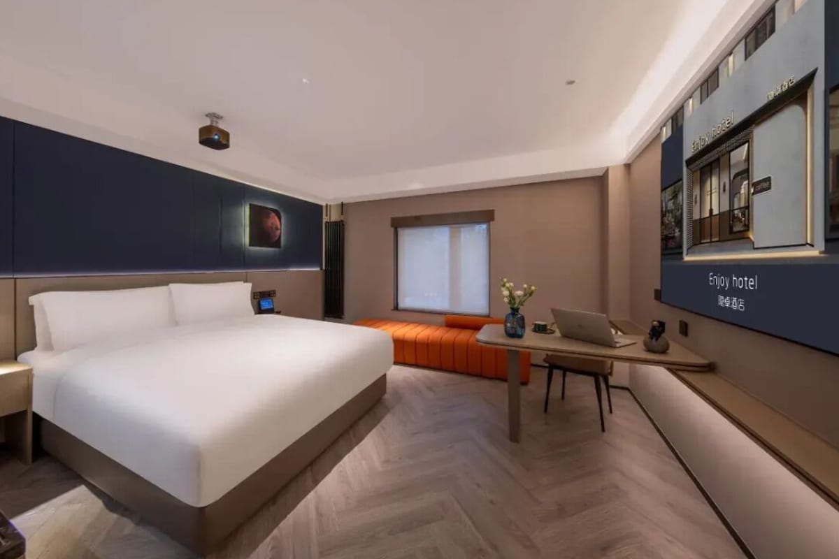 Une chambre d’hôtel moderne, dotée d’un grand lit, d’un bureau et d’un coin salon.