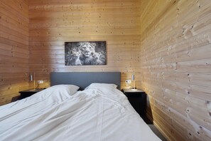 A wooden-paneled room with a bed, two bedside tables, and a painting on the wall. - Country Holiday home with shared pool (Someren-Heide)
