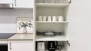 Eine Küche mit weißen Schränken, einem Toaster, einem Wasserkocher und einer Kaffeemaschine auf der Arbeitsfläche.