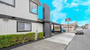 A building with a white facade, a black brick chimney, and a sign thanking patrons. - 1 King Bed | Non-Smoking, Kitchen (Eureka)