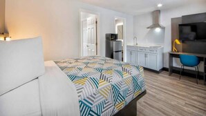 A bedroom with a bed, a desk, a chair, a television, a microwave, and a sink. - 1 King Bed | Non-Smoking, Kitchen (Eureka)