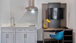 Una cocina moderna con estufa integrada, pileta y alacenas.