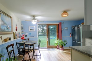 A kitchen with a dining area, a ceiling fan, a refrigerator, and a view through a glass door to an outdoor area. - Trailside Escape! Cozy Stormville Apartment (Stormville)