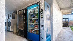 A row of vending machines with a blue and silver design, located in an outdoor area with a concrete floor and a wall. - 1 Queen Bed | Non-Smoking, Micfridge (Eureka)