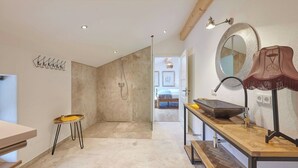 Ein modernes Badezimmer mit Dusche, Waschbecken und Spiegel.