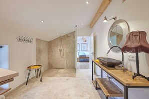 Un baño moderno con ducha, lavabo y espejo.