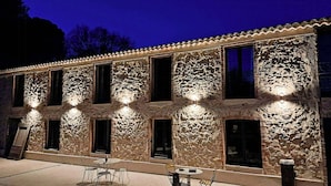 Ein Gebäude mit mehreren Fenstern und einer Terrasse mit Tischen und Stühlen.
