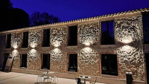 Ein Gebäude mit mehreren Fenstern und einer Terrasse mit Tischen und Stühlen.