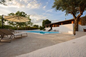 A pool area with lounge chairs, a covered seating area, and a staircase leading to a building. - Villa Chiaramonte Gulfi (Chiaramonte Gulfi)