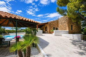 A covered outdoor area with a pool, stone building, and greenery. - Villa Chiaramonte Gulfi (Chiaramonte Gulfi)