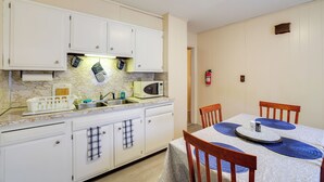 A kitchen with white cabinets, a microwave, and a sink. There is a dining table with chairs and a placemat. - Walk to Falls, Casino! Niagara Family Home w/ Yard (Niagara Falls)