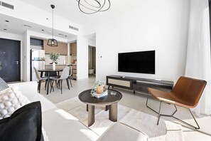Ein modernes Wohnzimmer mit Sofa, Couchtisch und Fernseher.