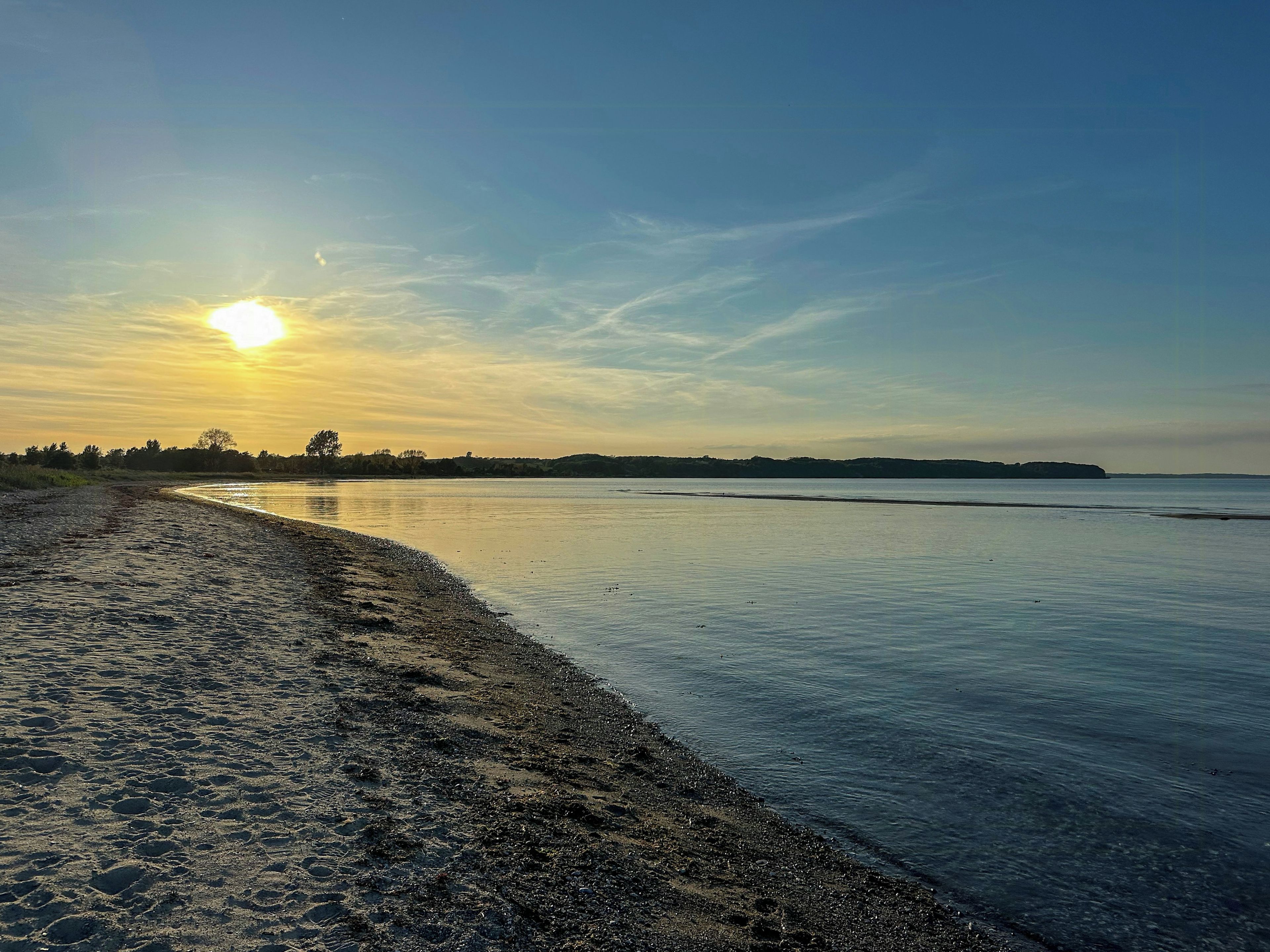 Ein Strand mit klarem Himmel und Sonnenuntergang oder -aufgang.