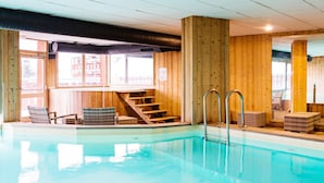 Una piscina interior con paredes de madera y una escalera que sube a un nivel superior.
