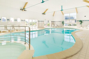 An indoor swimming pool with clear water, white lounge chairs, and large windows. - Loire Valley Duplex Maisonette (Azay-le-Rideau)