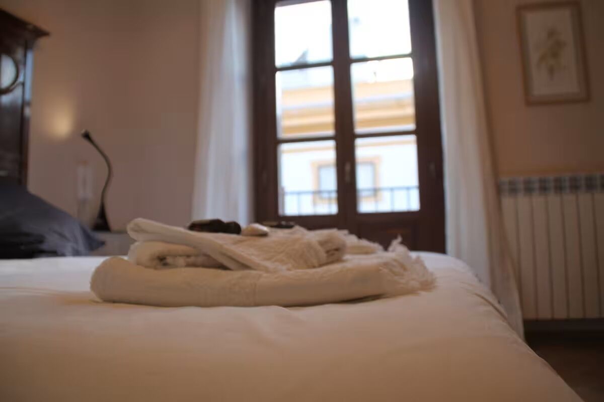 A bed with towels, a window with a view, and a radiator.