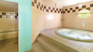 A bathroom with a bathtub, tiled walls, and a window. - Seaside Apartment for 4 in Var (Six-Fours-les-Plages)