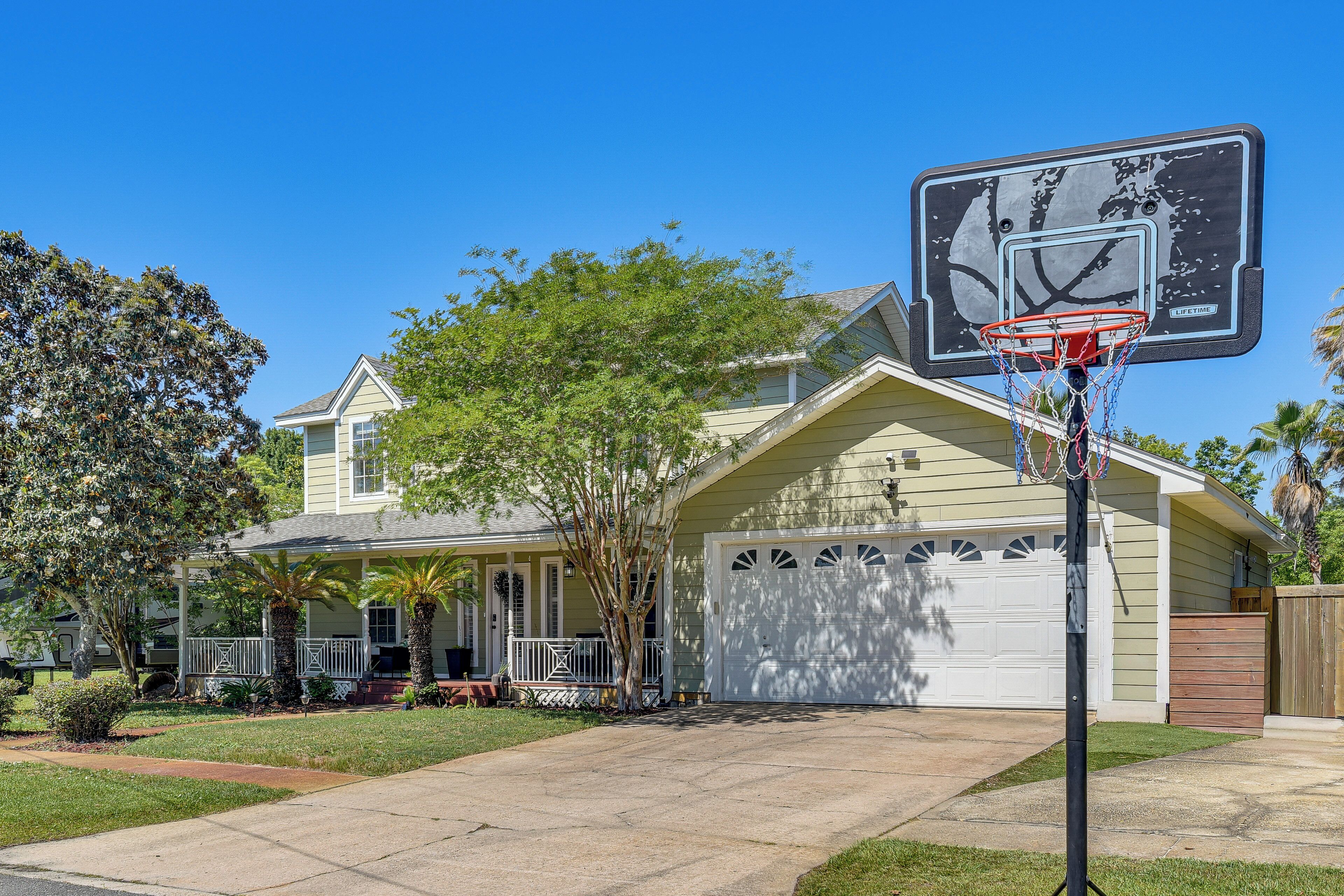 Una casa residenziale con un canestro da basket nel giardino.