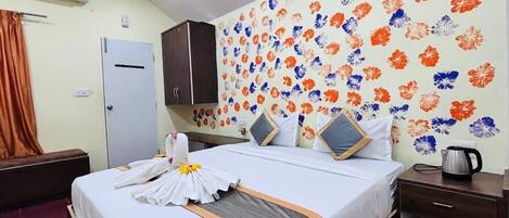 Una habitación de hotel con cama, armario, escritorio y papel tapiz floral.