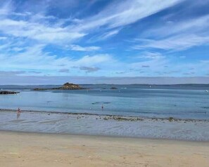 A beach with clear water, a sandy shore, and a distant rocky outcrop. - Character house facing Douarnenez bay (Douarnenez)