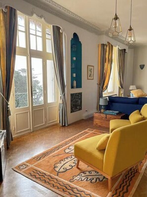 A living room with a sofa, curtains, and a patterned rug. - Character house facing Douarnenez bay (Douarnenez)