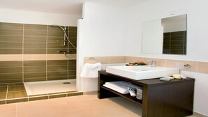 Un baño moderno con ducha, lavabo y espejo.