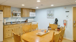 A kitchen with wooden cabinets, a microwave, a stove, and a dining table with chairs.