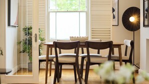 Un comedor con sillas de madera, una mesa y una lámpara de pie.