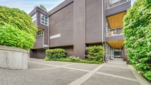 Un bâtiment moderne doté d’un toit plat, de grandes fenêtres et d’une entrée abritée.