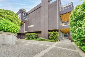 Ein modernes Gebäude mit Flachdach, großen Fenstern und einer überdachten Eingangspartei.