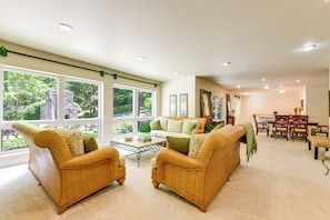 A spacious living room with large windows, a dining area, and a kitchen in the background. - Group-Friendly Mtn Estate 2 Mi to Dtwn Waynesville (Waynesville)