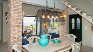 Ein Essbereich mit einem Holztisch, Stühlen, einem blauen Sofa und einer dekorativen Vase.
