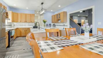 Una cocina moderna con armarios de madera, una isla central y una zona de comedor con un mantel a cuadros.