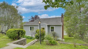 A residential house with a front yard, a stone planter, and a street lamp. - Lakefront Bliss in Mahopac! Charming Home w/ Dock (Mahopac)