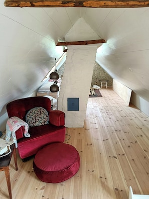 A cozy room with a red sofa, a small table, and a wooden floor.