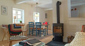 A cozy living room with a fireplace, wooden furniture, and a bookshelf.