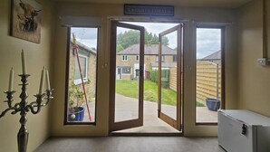 A room with a door leading outside, a sign reading 'Naughty Corner,' and a small white cabinet. - Tranquil Hope Valley Retreat With 3 Bedrooms (Hope Valley)