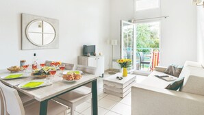 Una sala moderna con comedor, televisor y balcón con vistas.
