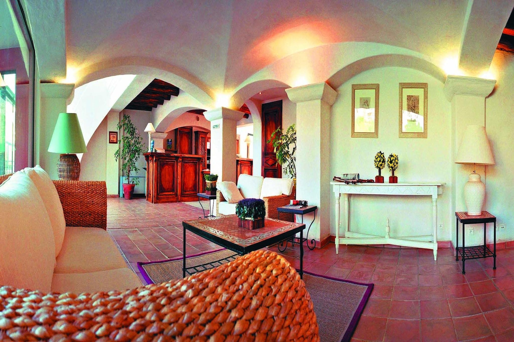 A spacious living area with a sofa, armchairs, a coffee table, and a fireplace.