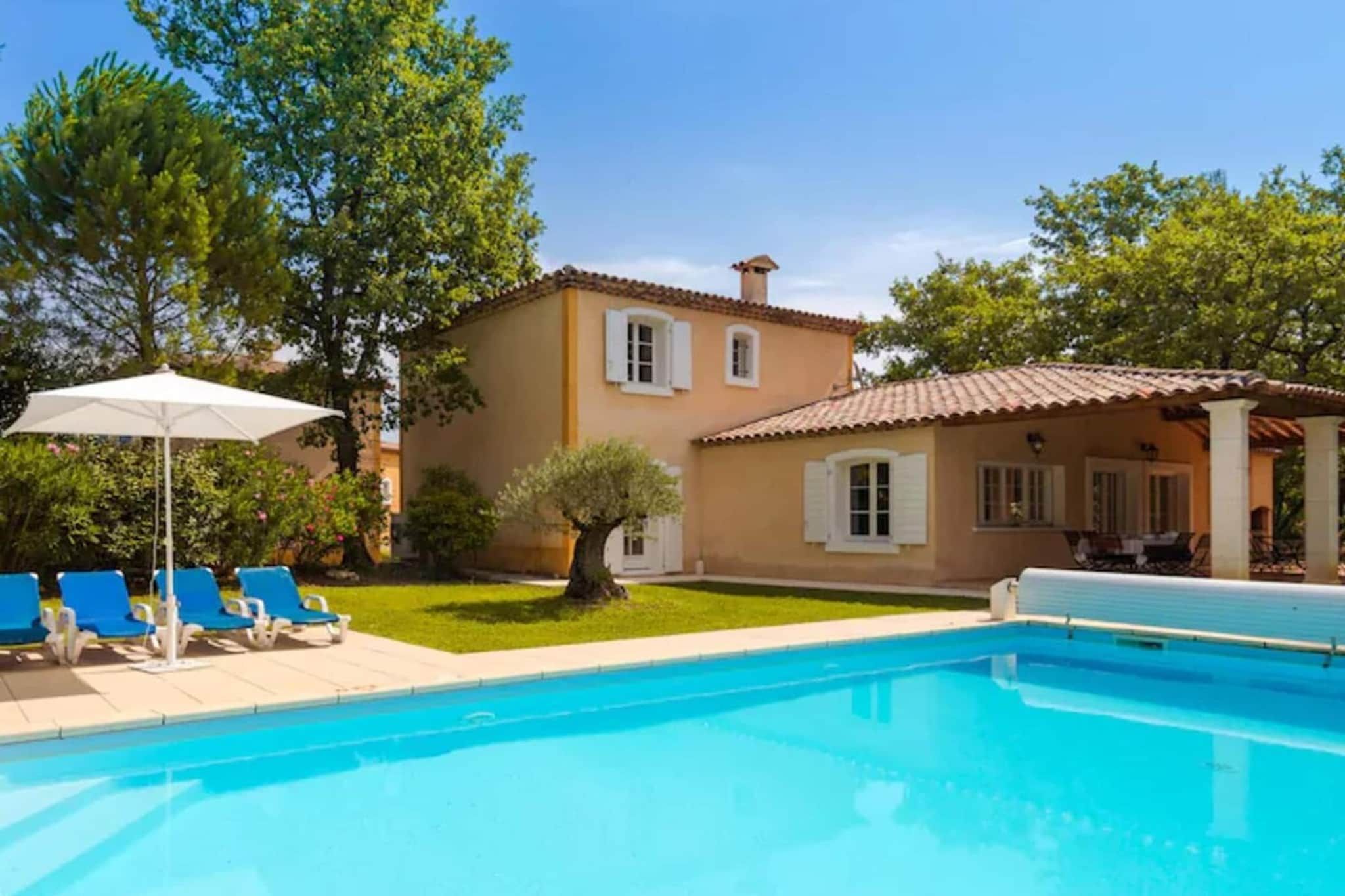 A swimming pool with lounge chairs and a patio umbrella.
