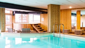 Une piscine intérieure avec des murs en bois et un escalier menant à un niveau supérieur.