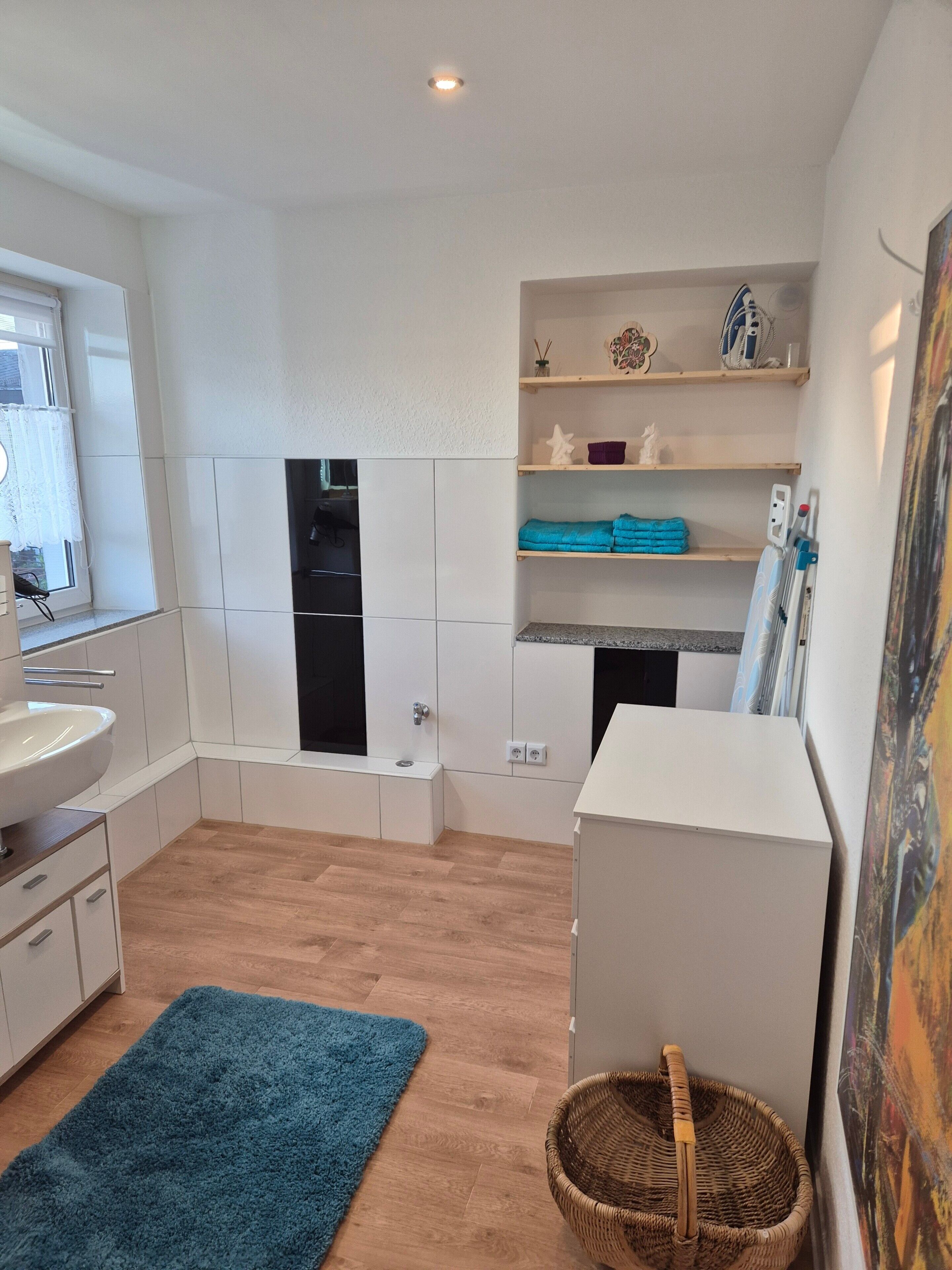 A modern kitchen with white cabinets, a built-in oven, and a sink.