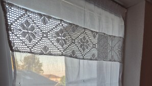 A window with a white curtain and a lace trim.