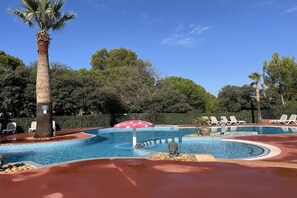 A pool area with multiple pools, lounge chairs, and a Buddha statue. - Cottage Escape near Cap d’Agde (Agde)