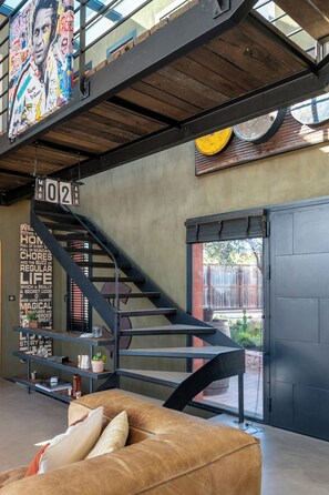 Ein modernes Interieur mit Treppe, einer Couch und einer Wand mit Text und Bildern.