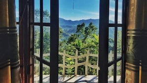 An open door with a view of a mountainous landscape and greenery. - Helly mount inn (Ella)