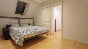 A bedroom with a bed, a nightstand, a window with a view, and a door leading to another room. - Renovated house in Courteuil near Chantilly (Courteuil)