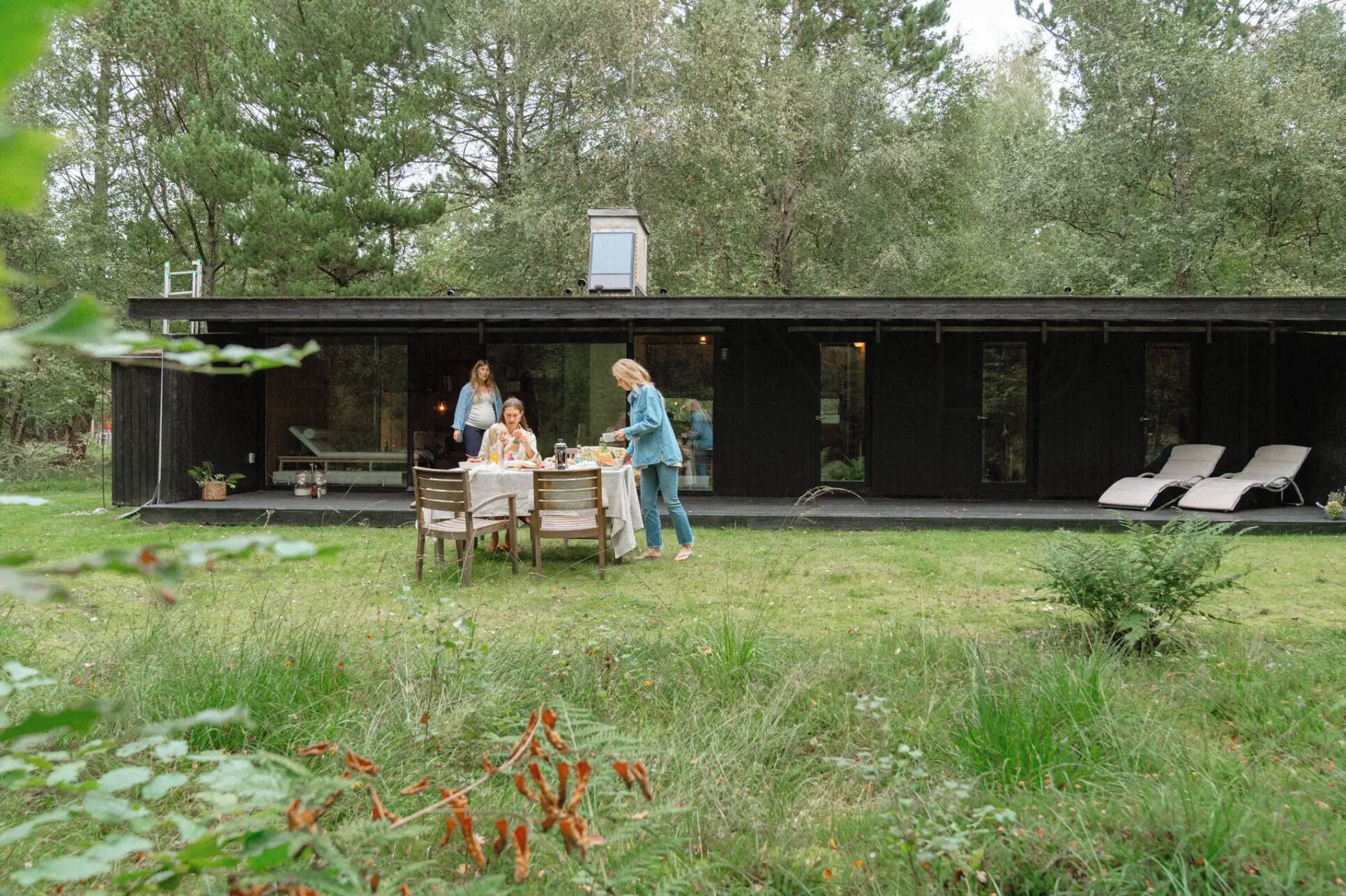 A modern, minimalist house with a dining area and outdoor seating.